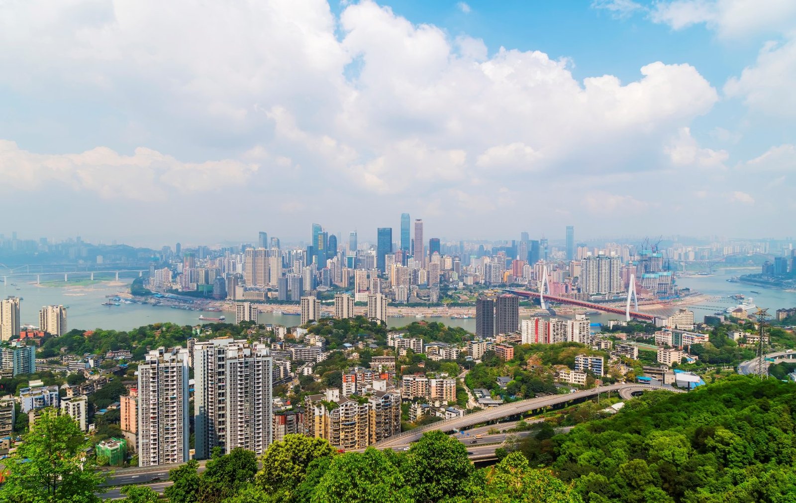 City skyline with modern residential towers and green hills